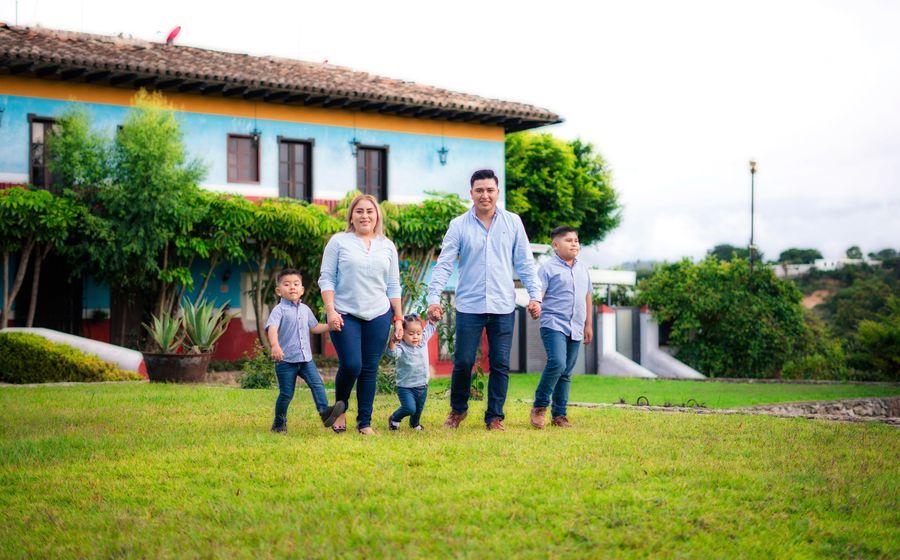 A family walking together through the garden in front of their home