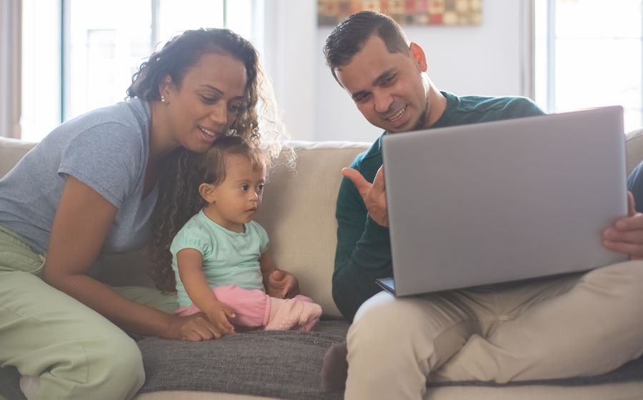 A family looking at a laptop together on the couch